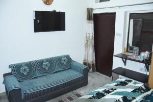 a living room with a blue couch and a television at Angel's Cottage in Jaipur