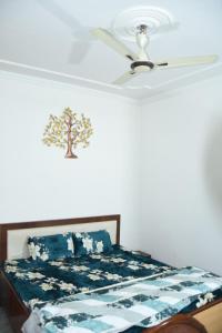 a bedroom with a bed with a ceiling fan at Angel's Cottage in Jaipur