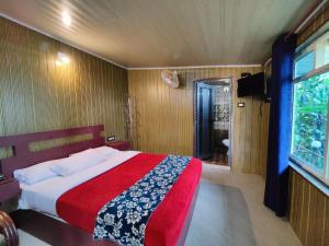 a bedroom with a large bed and a window at Munnar Plantation Villa in Munnar