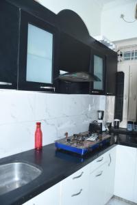 a kitchen with a black counter top and a stove at Angel's Cottage in Jaipur +18 photos