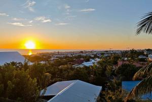 a sunset over a city with houses and trees at La Kaz Sumac in Saint-Pierre
