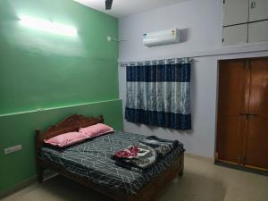 a bedroom with a bed with pink pillows and a window at Elixir Mansion in Pālakollu