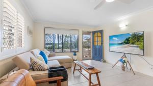 a living room with a couch and a tv at Driftwood At Beachmere in Beachmere