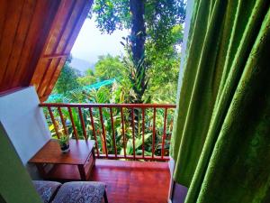 a room with a balcony with a table and a window at Munnar Plantation Villa in Munnar