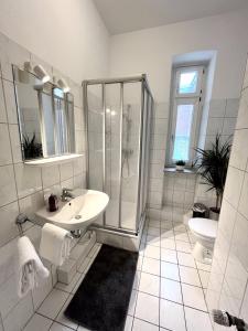a white bathroom with a shower and a sink at N&N City Apartment Schwerin mit Parkplatz in Schwerin
