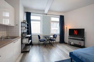 a small kitchen with a table and chairs in a room at N&N City Apartment Schwerin mit Parkplatz in Schwerin