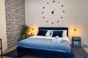 a bedroom with a bed with a clock on the wall at N&N City Apartment Schwerin mit Parkplatz in Schwerin