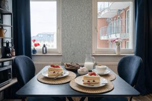 a table with two slices of cake on it at N&N City Apartment Schwerin mit Parkplatz in Schwerin