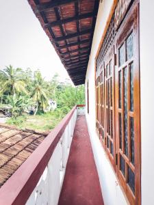 a corridor on the side of a building with a window at Indrasiri Villa Midigama in Kumbalgama