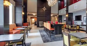 a restaurant with tables and chairs and a bar at Hampton Inn and Suites Marksville in Mansura