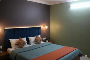 a bedroom with a bed with a blue headboard and pillows at Anand Comfort in Anakāpalle