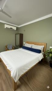 a large bed with white sheets and blue pillows at Anand Comfort in Anakāpalle