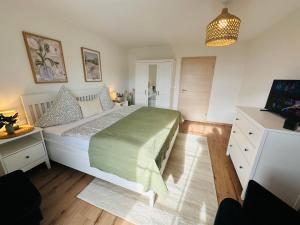 a bedroom with a large bed with a green blanket at Ferienwohnung Alpen Auszeit in Rieden
