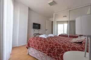 a bedroom with a bed with a large mirror at Edificio Guttero in Caleta Olivia