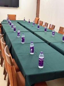 a row of green tables with bottles of water on them at Ocean White Sands Resort & Spa in Varca +36 photos