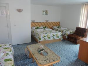 a hotel room with two beds and a coffee table at Sianie Guest House in Ravda