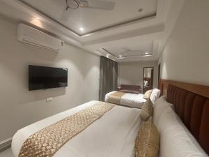 a hotel room with two beds and a flat screen tv at Hotel Annant Jawai in Sheoganj