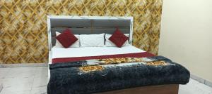 a bedroom with a bed with a bunch of pillows at Sheetal palce hotel in Ujjain