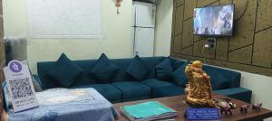 a living room with a blue couch and a table at Sheetal palce hotel in Ujjain