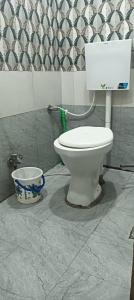 a bathroom with a toilet and a bucket at Sheetal palce hotel in Ujjain