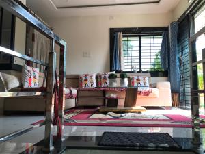 a living room with a couch and a table at Vishnoo Stays Lush Green Room in Atal Nagar in Nawāgaon