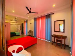 a bedroom with a red bed and a desk at The Ondoro in Kamburugamuwa
