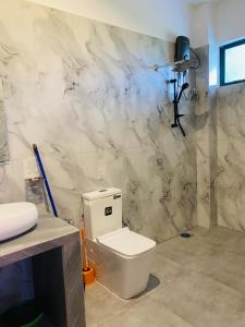 a bathroom with a toilet and a marble wall at The Ondoro in Kamburugamuwa +38 photos