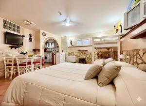 a bedroom with a large white bed and a kitchen at OPEN SPACE Littoria in Latina