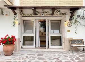 a porch with glass doors and a vase of flowers at OPEN SPACE Littoria in Latina