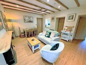 a living room with a couch and a table at Bumblebee Cottage-Uk39918 in Ballakinnag