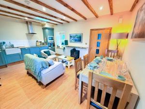 a kitchen and living room with a table and a couch at Bumblebee Cottage-Uk39918 in Ballakinnag