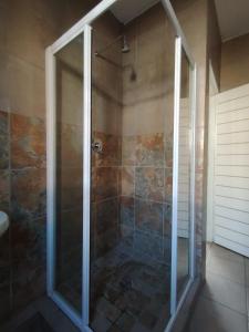 a shower with a glass door in a bathroom at Tubalala Properties in Rustenburg