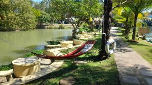 a hammock tied to a tree next to a river at LLamados Fishing Lake in San Kamphaeng