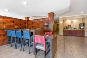 a bar in a restaurant with blue and red chairs at Comfort Suites Elizabethtown in Elizabethtown