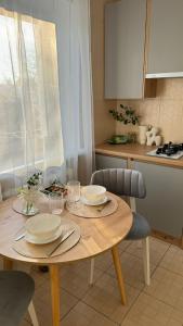 a kitchen with a table with plates on it at Апартаменти GREEN центр вулиця Руська in Ternopil