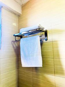 a towel rack with towels on a wall at The Hidden Gem Near Central B&B in Nkunjila