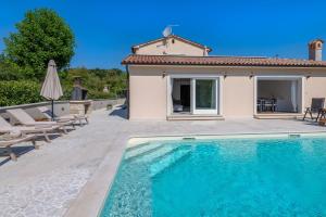 a villa with a swimming pool in front of a house at Villa Gino in Pazin