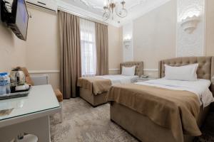 a hotel room with two beds and a television at Hotel B&S Samarkand Boutique in Samarkand +27 photos