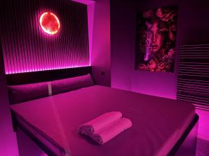 a pink bedroom with a bed with two towels on it at SPA SPA Petrská hostel in Prague +7 photos