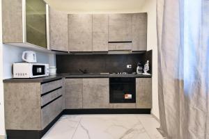 a kitchen with stainless steel cabinets and a microwave at Appartamento Delfino in Rimini