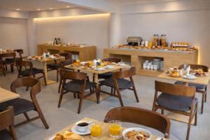 a restaurant with tables and chairs with food on them at City Crown Hotel in Dar es Salaam