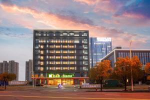 a tall building with a lot of windows in a city at Ibis Styles Nantong North High-tech Zone in Nantong