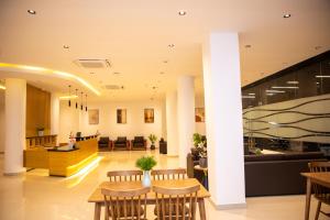 a lobby with tables and chairs in a building at City Crown Hotel in Dar es Salaam