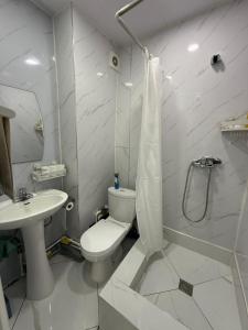 a white bathroom with a toilet and a sink at Mini apartment in Central UB in Ulaanbaatar +12 photos