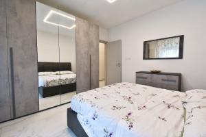 a bedroom with a large bed and a mirror at Appartamento Delfino in Rimini