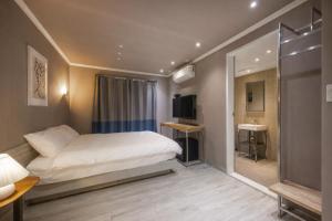 a small bedroom with a bed and a bathroom at Tinto Hotel Busan Station in Busan
