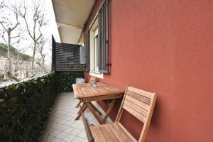 a wooden table and chair sitting on a balcony at Appartamento Delfino in Rimini