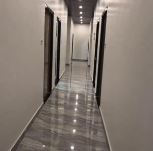 a long hallway with doors and a tile floor at Sri Ram Shankar-Saryu Ghat in Ayodhya