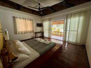 a bedroom with a bed with two stuffed animals on it at La Natura Resort in Coron