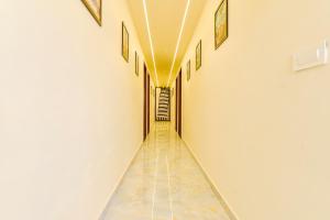 a long hallway with a tile floor and white walls at FabHotel Blooming Beds Pearl in Jaipur
